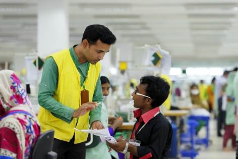 A worker with a disability and his colleague are discussing, Bangladesh